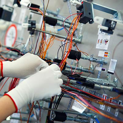 a worker builds a custom wiring harness